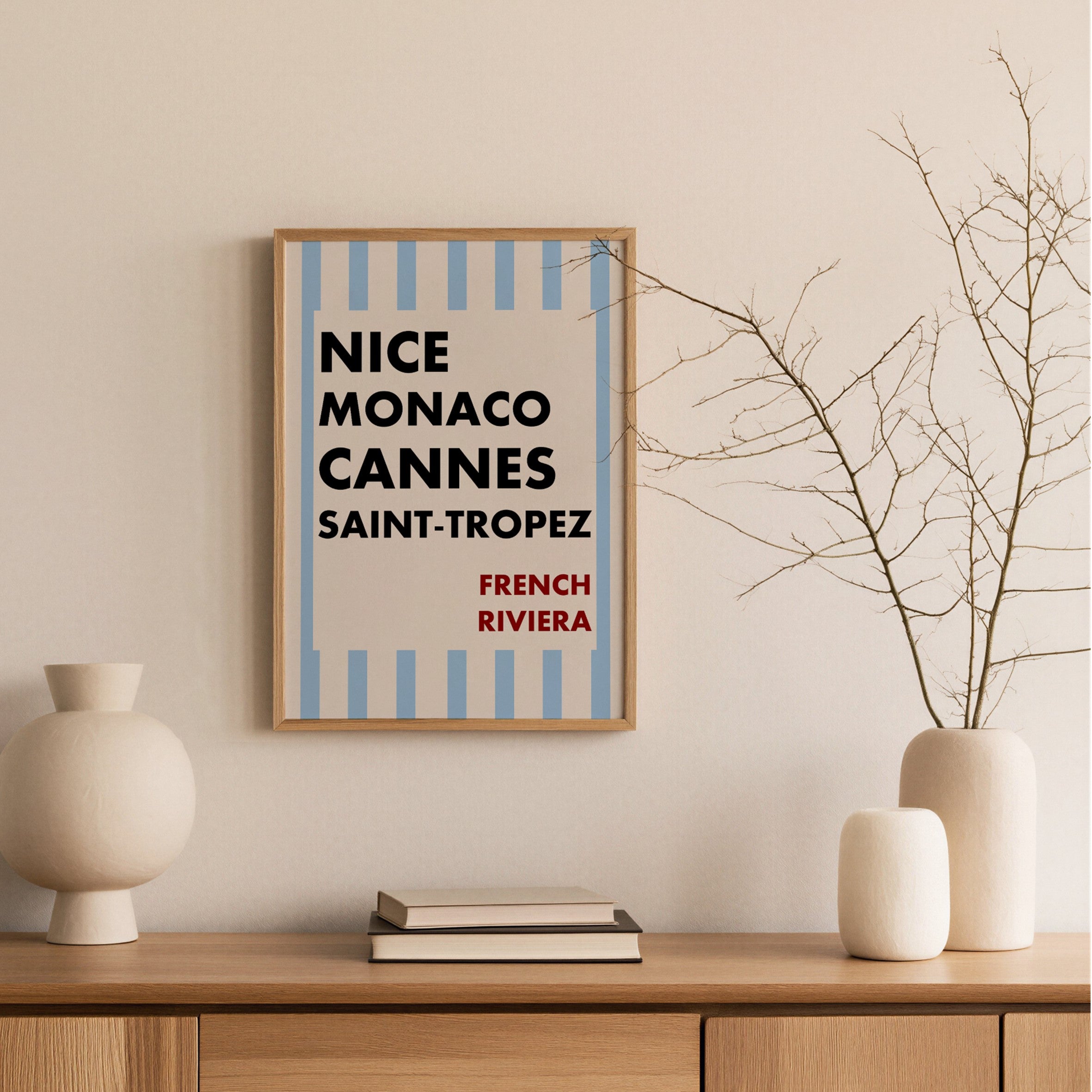 Framed poster with text on a wall above a wooden shelf with decorative items.