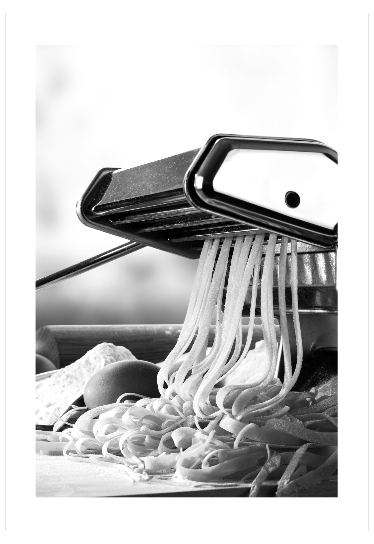 Pasta maker with fresh pasta being extruded on a white background