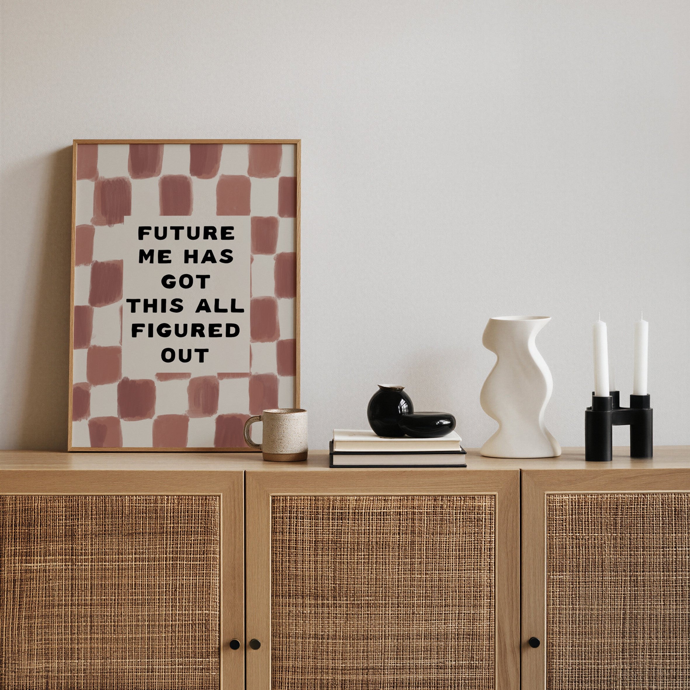 Framed artwork with motivational quote on a wooden cabinet with decorative items.