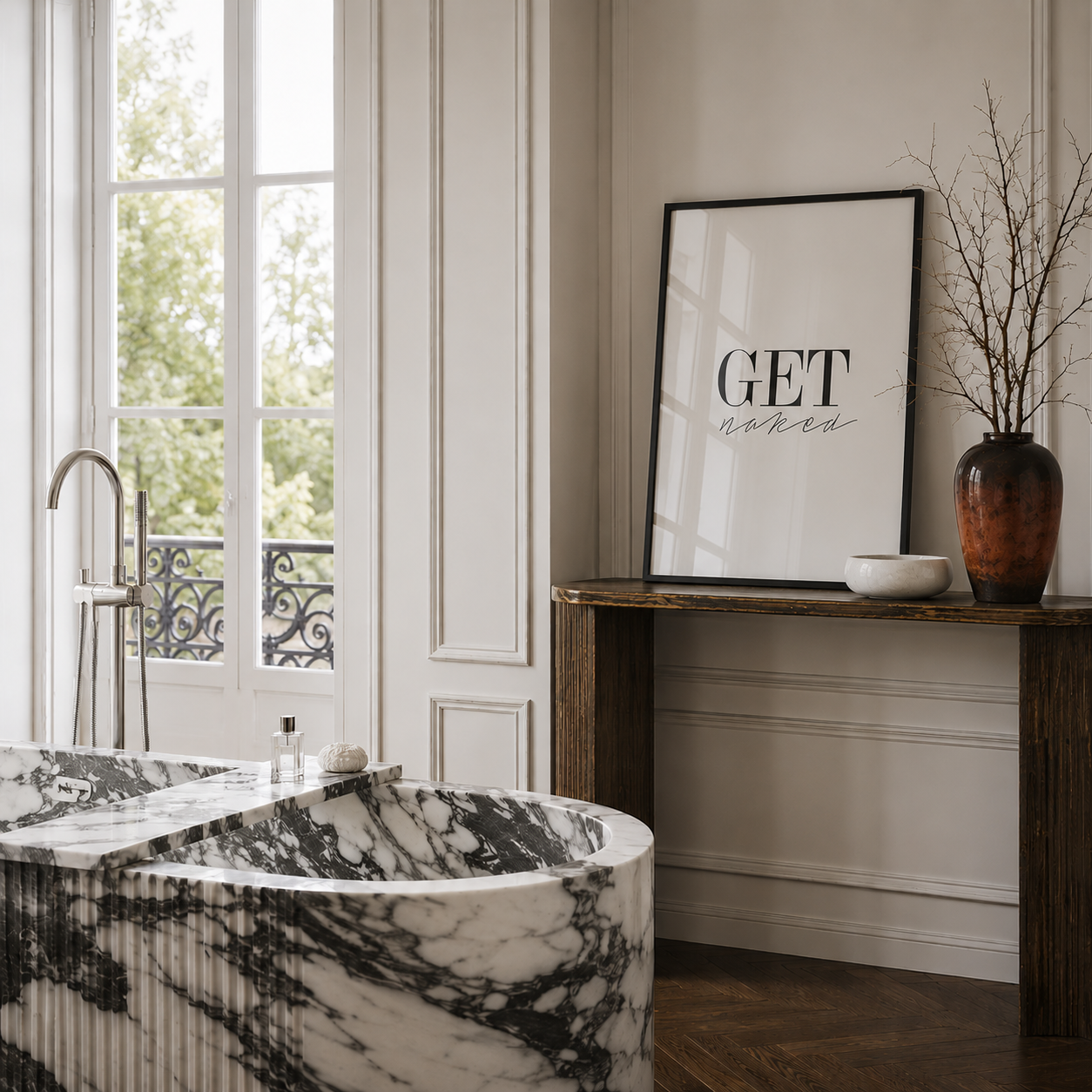 Modern bathroom with marble bathtub, framed art, and decorative elements.