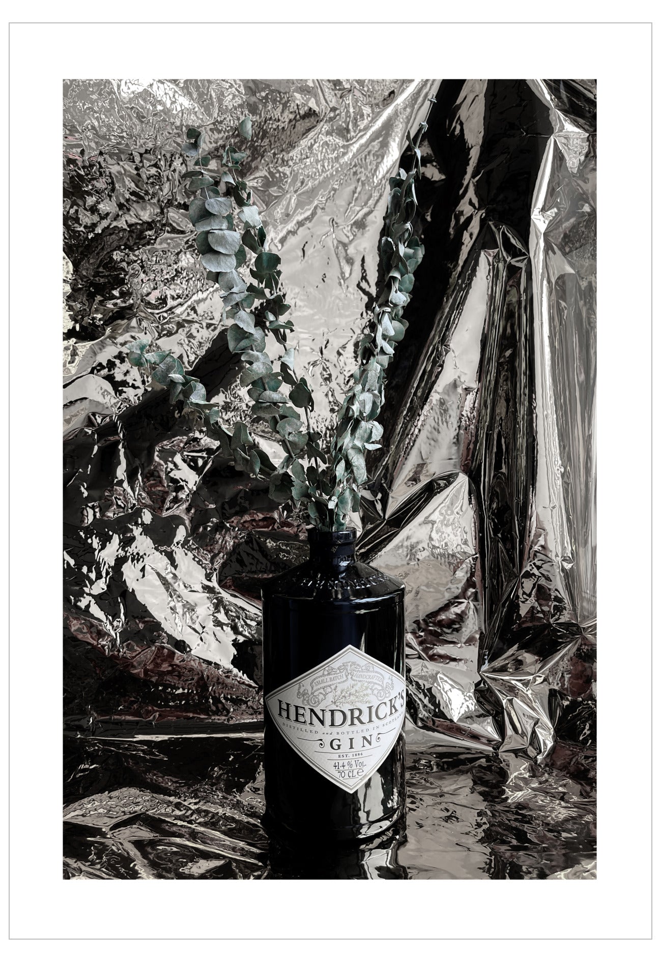Bottle of Hendrick's Gin surrounded by foliage and reflective surface