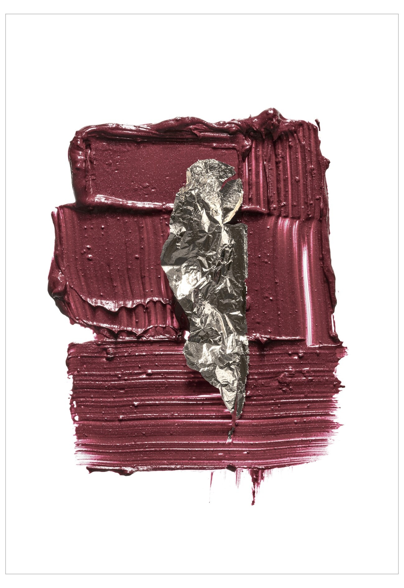 Close-up of a maroon lipstick with a leaf on a white background