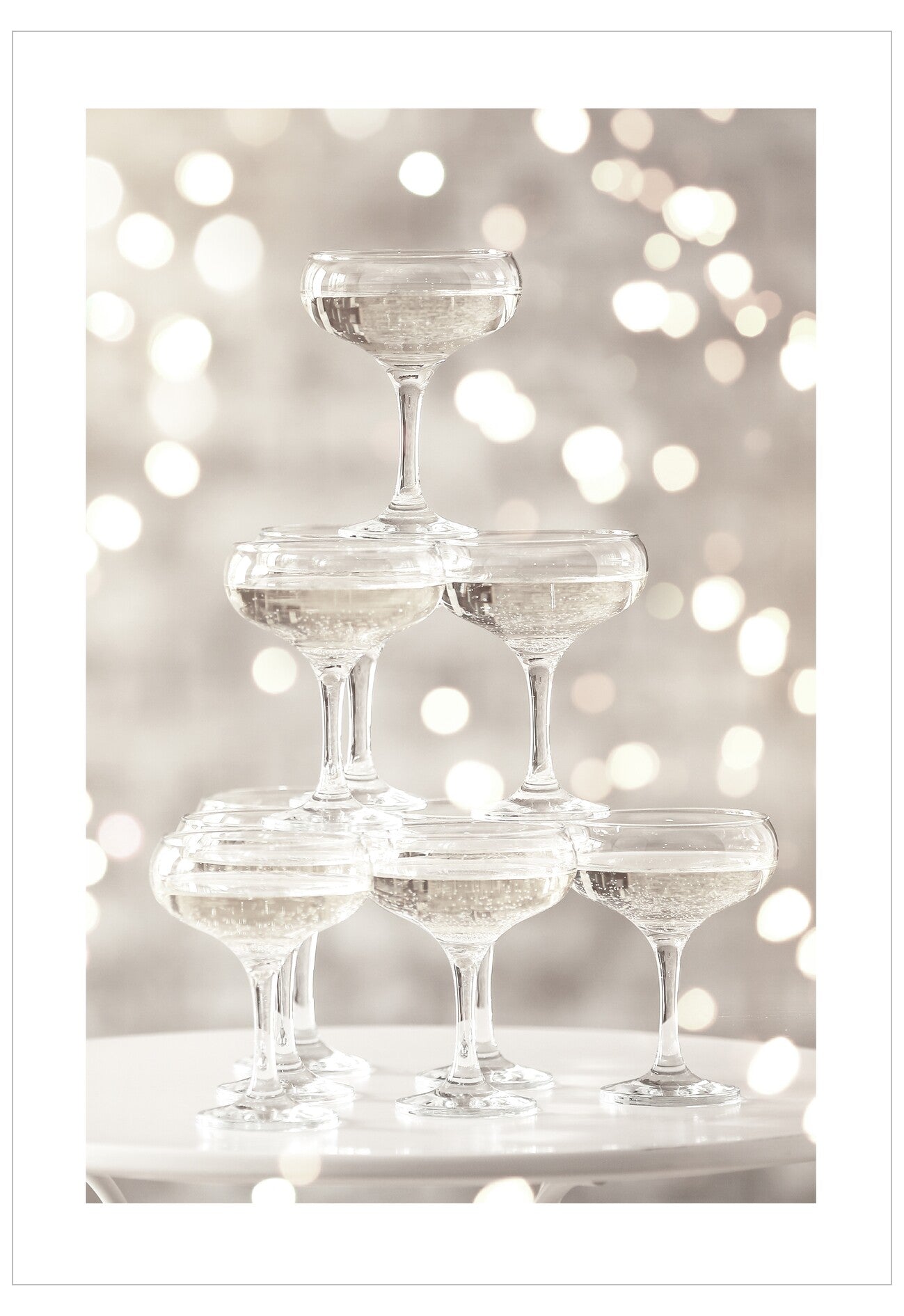 Stack of champagne glasses against a bokeh light background