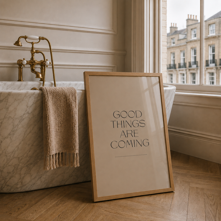 Framed poster with 'Good Things Are Coming' text in a bathroom setting.
