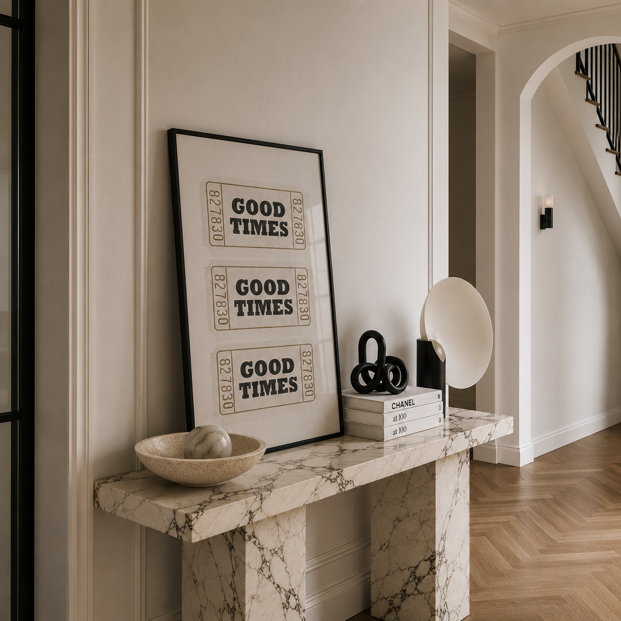 Marble console table with 'Good Times' framed print and decorative items in a home setting.