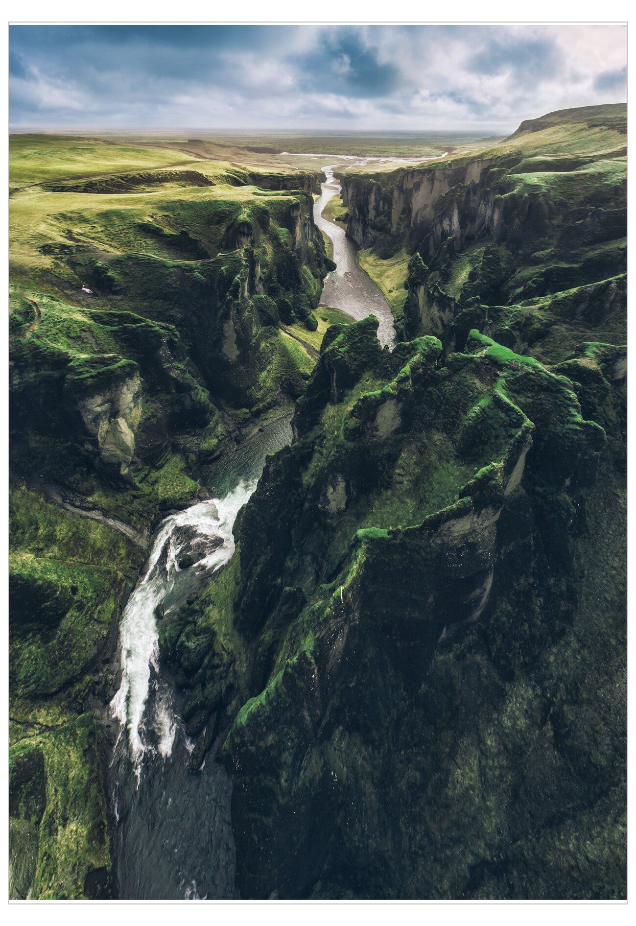 Aerial view of a green canyon with water flowing through it