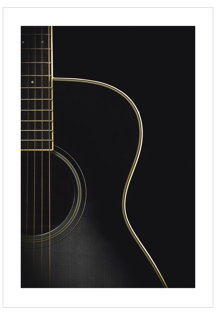 Close-up of a guitar's neck and body on a black background