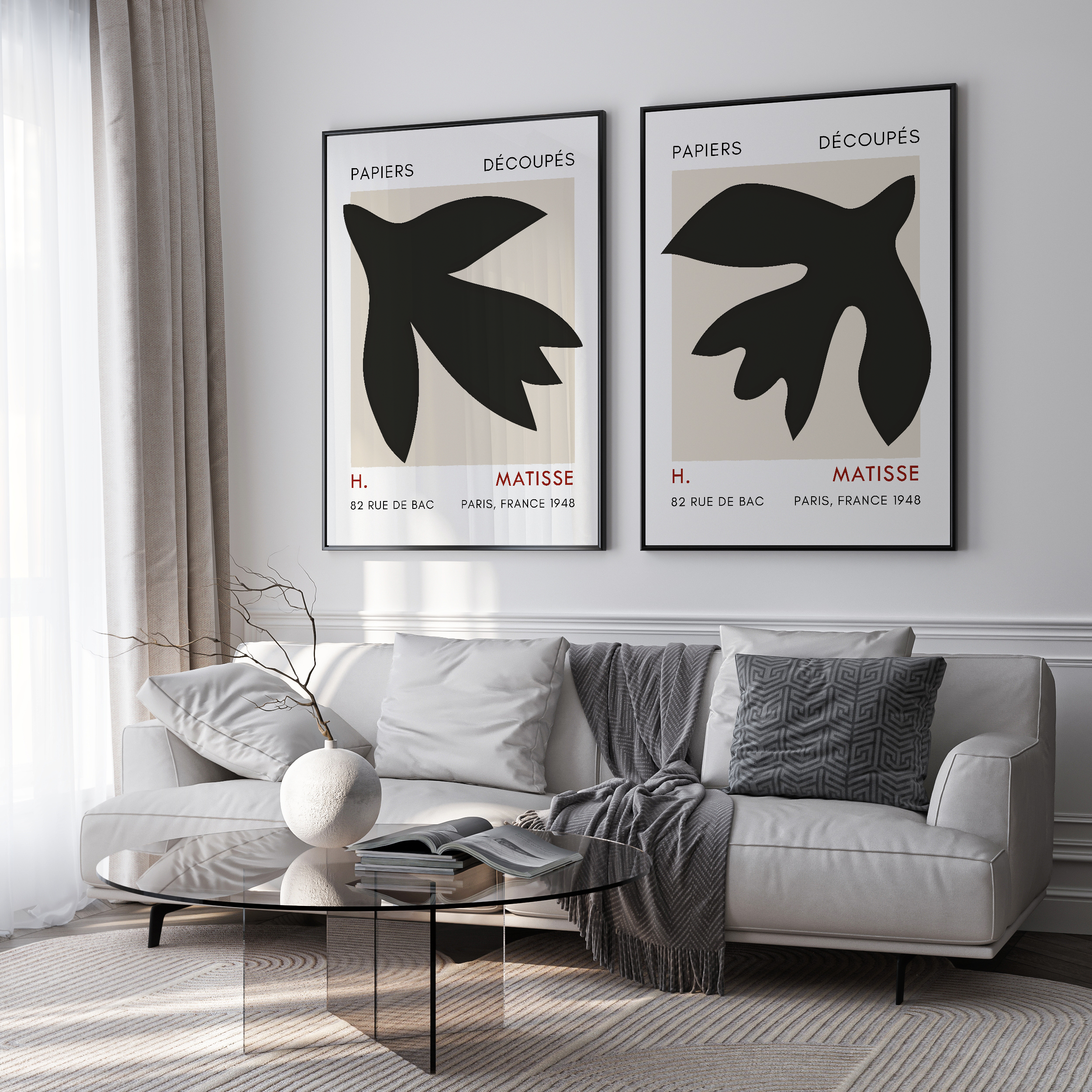 Living room with a sofa, coffee table, and two framed black and white artworks on the wall.