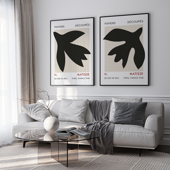 Living room with a sofa, coffee table, and two framed black and white artworks on the wall.
