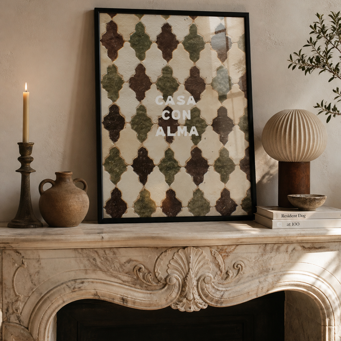 Decorative fireplace mantel with framed artwork, candles, and books.