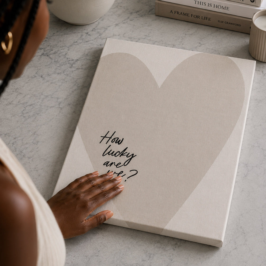 Book with a heart design and text on a surface, with a person's hand touching it.