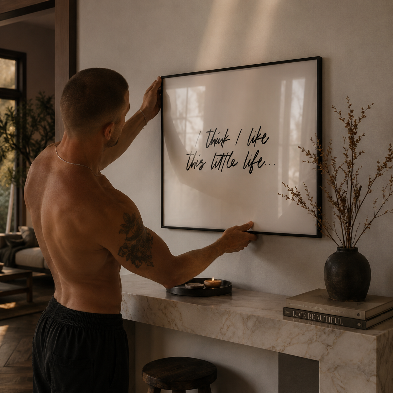 Man hanging a framed quote on a wall in a home setting