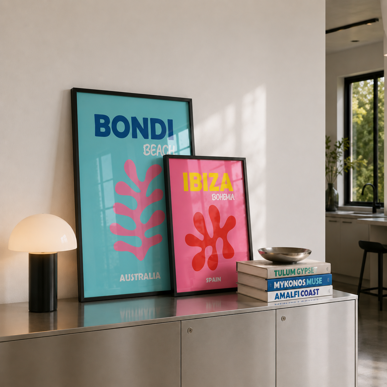 Two framed posters, one blue and one pink, on a shelf in a modern interior setting.