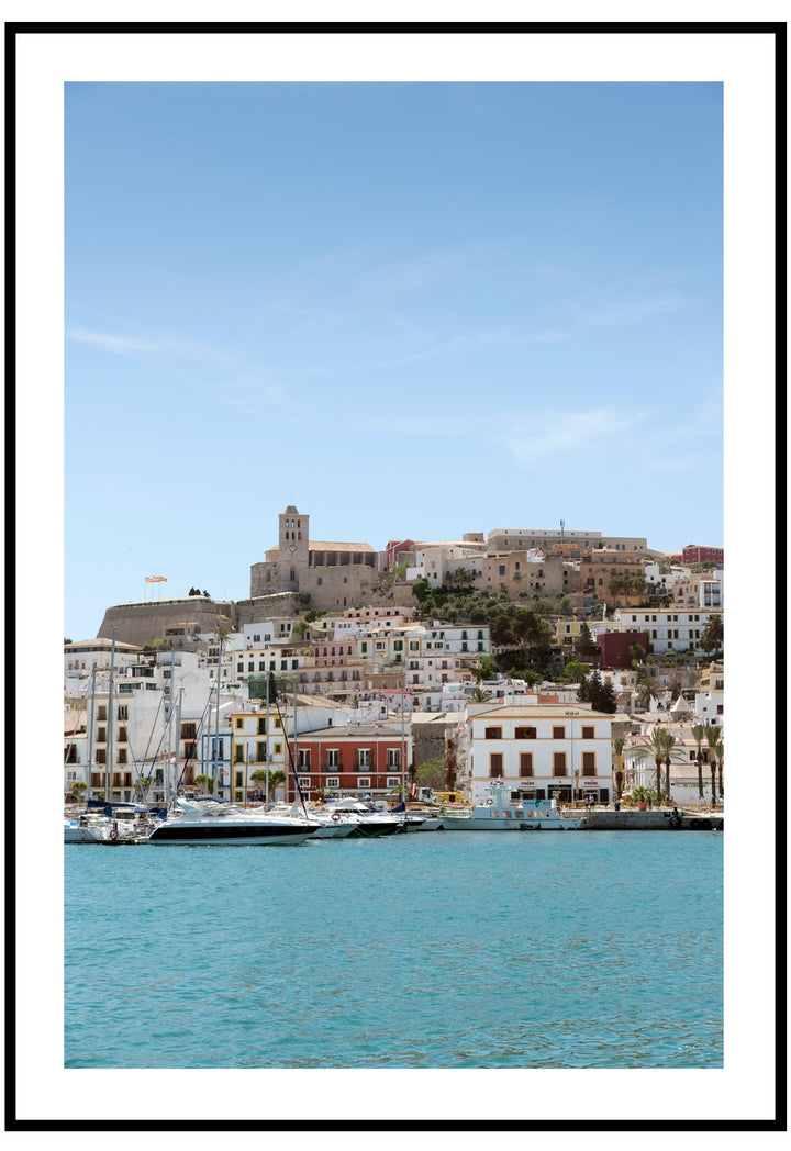 Ibiza poster with buildings on a hill overlooking a harbour with boats.
