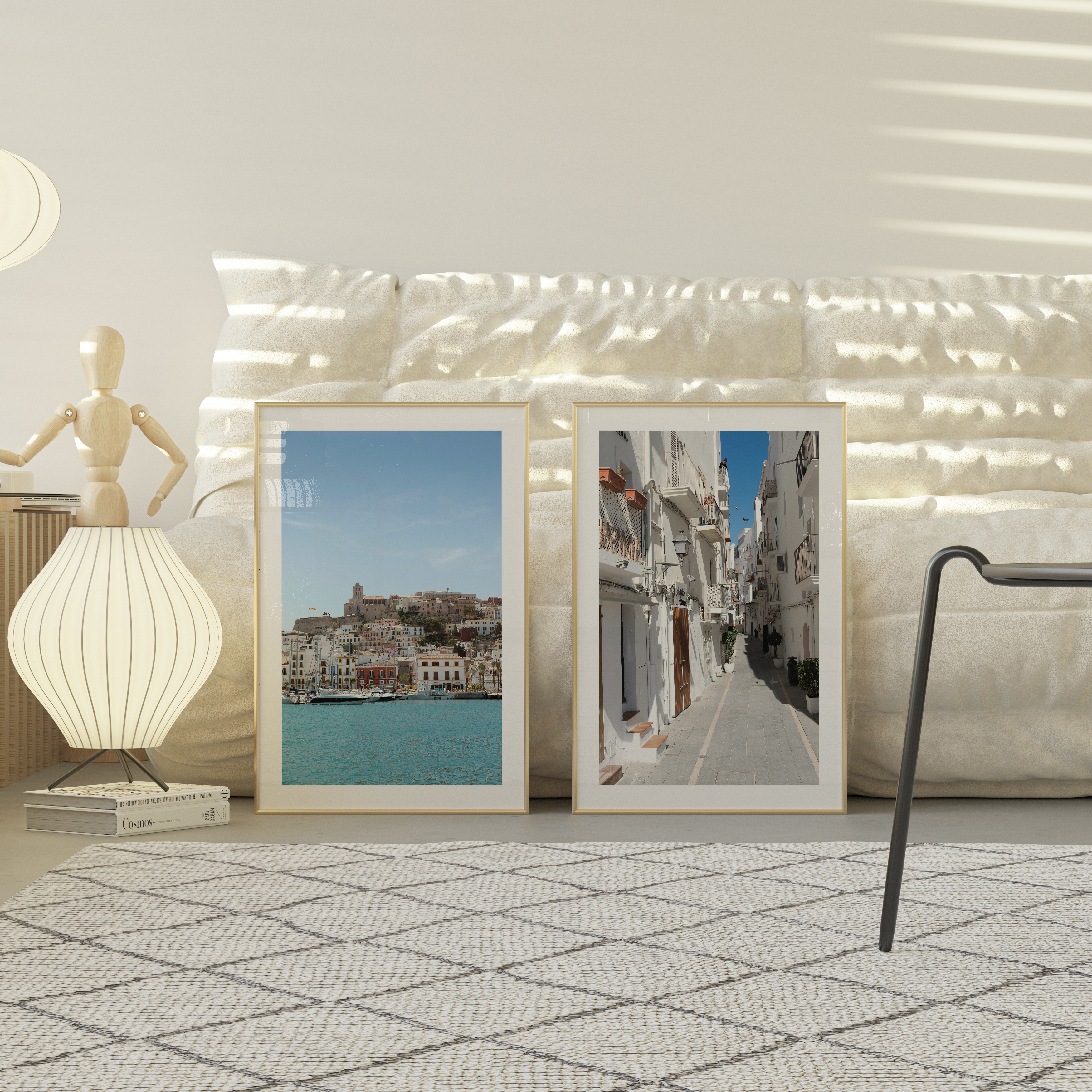 Two framed Ibiza artworks on a wall with decorative lights and a lamp.