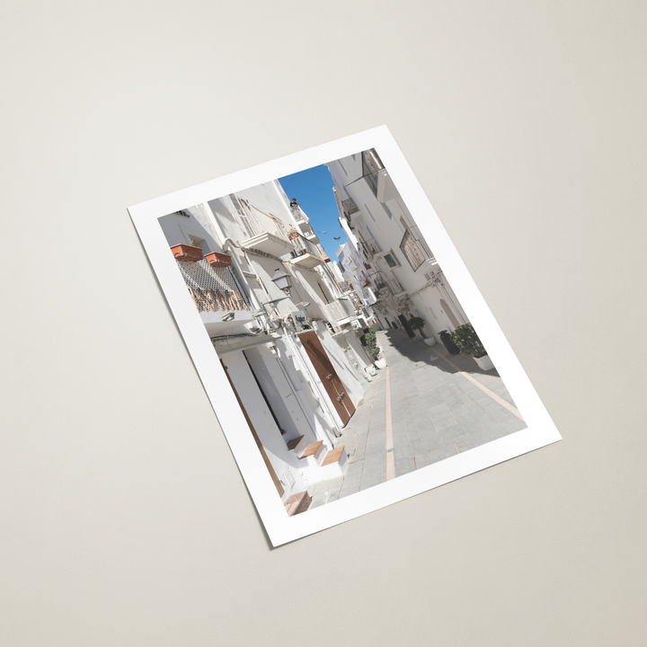 Poster with a scenic view of a street and buildings in Ibiza on a light gray background