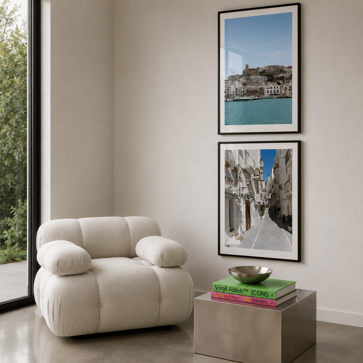 Modern living room with a beige armchair, side table, and framed pictures on the wall.