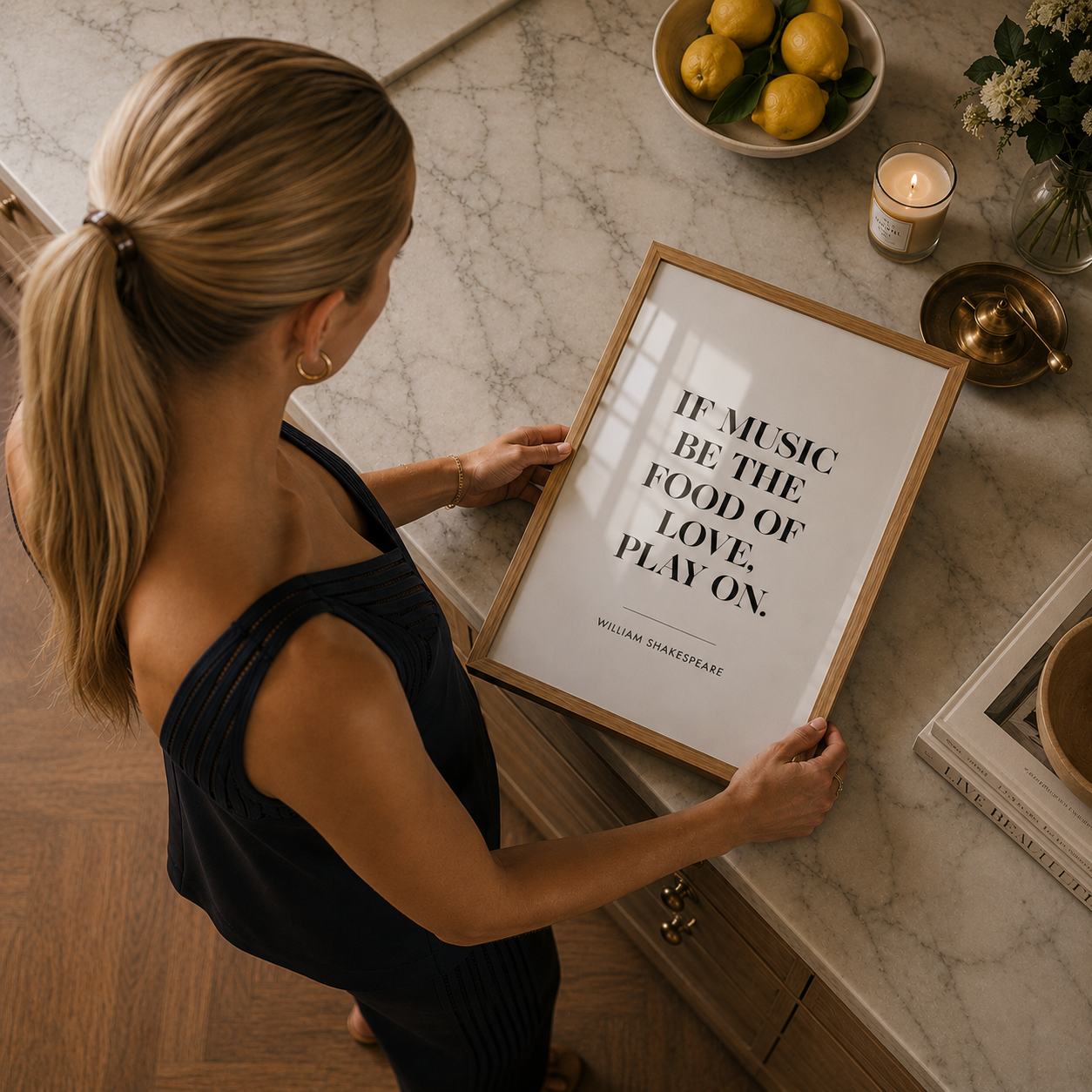 Woman holding a framed quote on a kitchen counter with lemons and candles in the background