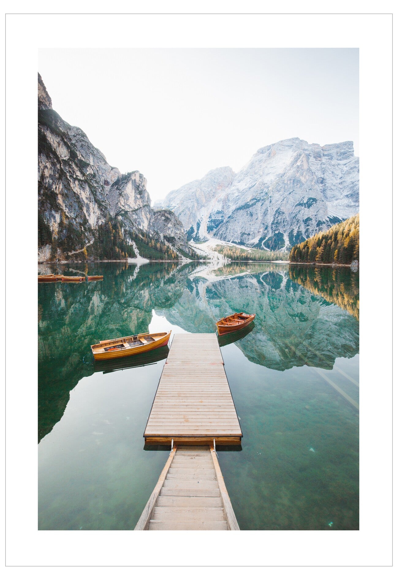 Wooden dock extending into a lake with mountains in the background