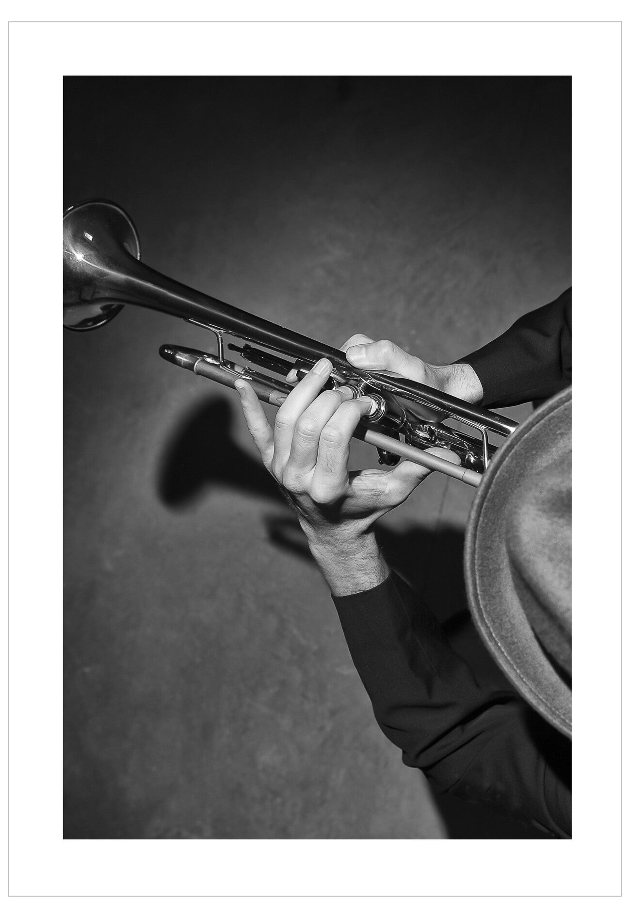 Black and white photo of a person playing a trumpet with a blurred background