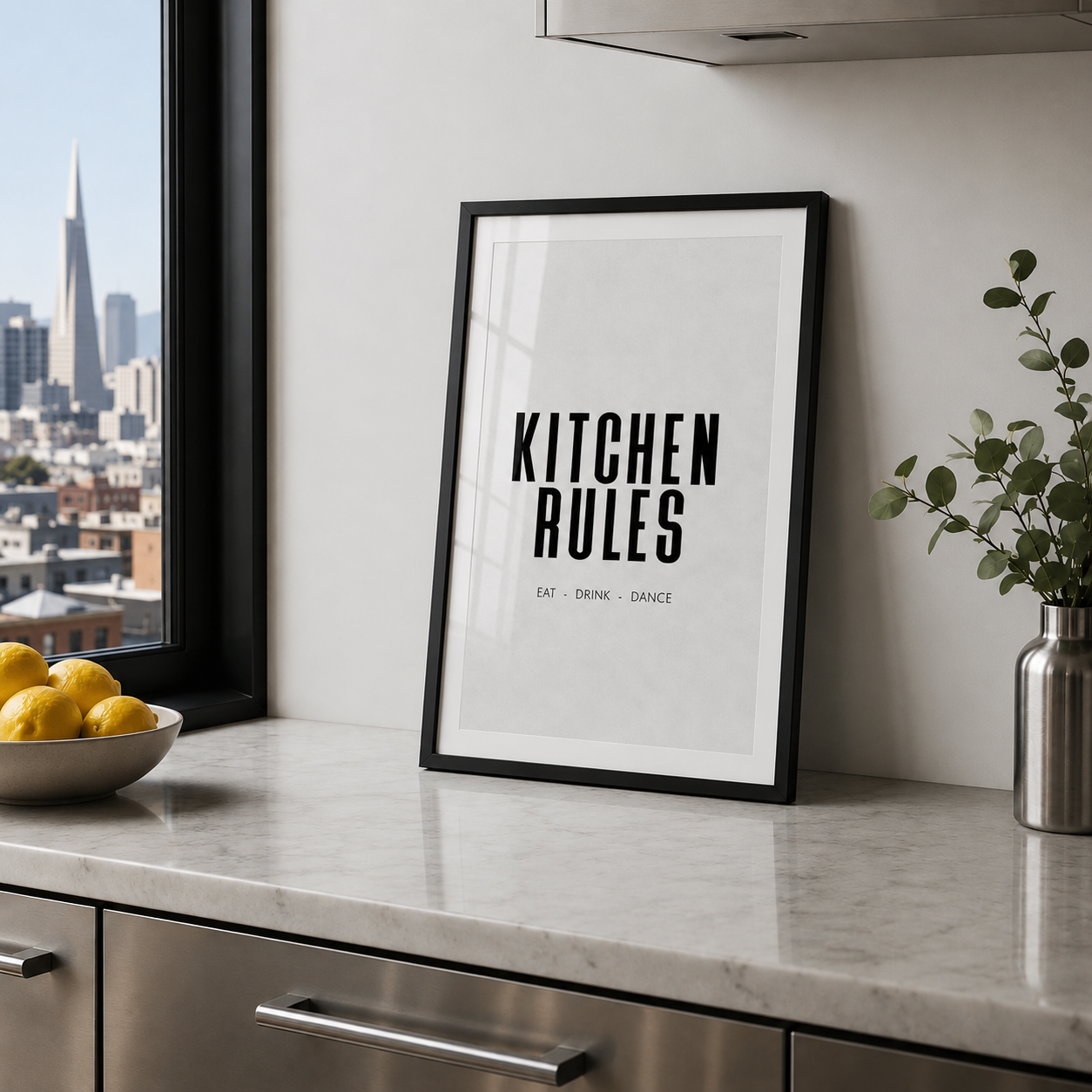 Kitchen Rules poster in black frame in stainless steel kitchen with marble worktops