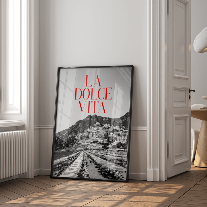 Framed artwork with 'La Dolce Vita' text in a room with a window and radiator.
