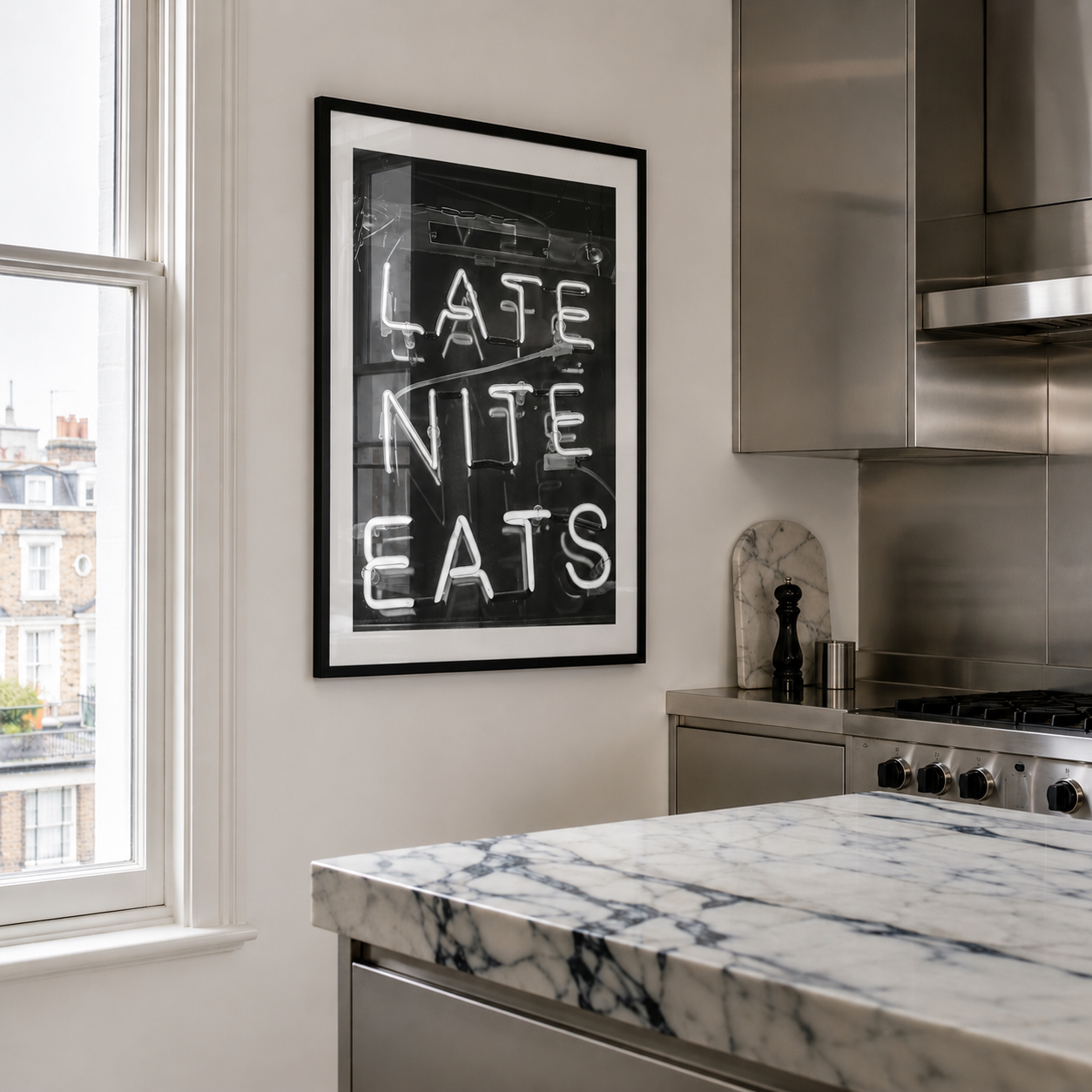 Modern kitchen with marble countertop, stainless steel appliances, and framed artwork on the wall.