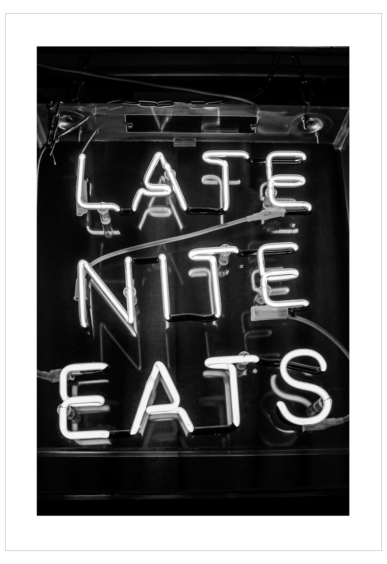 Neon sign with 'Late Nite Eats' text in black and white.