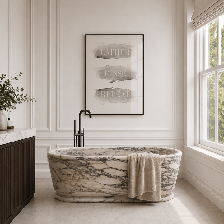 Marble bathtub in a bathroom with a framed artwork on the wall.