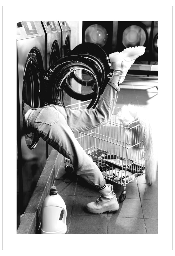 Person loading a washing machine in a laundromat