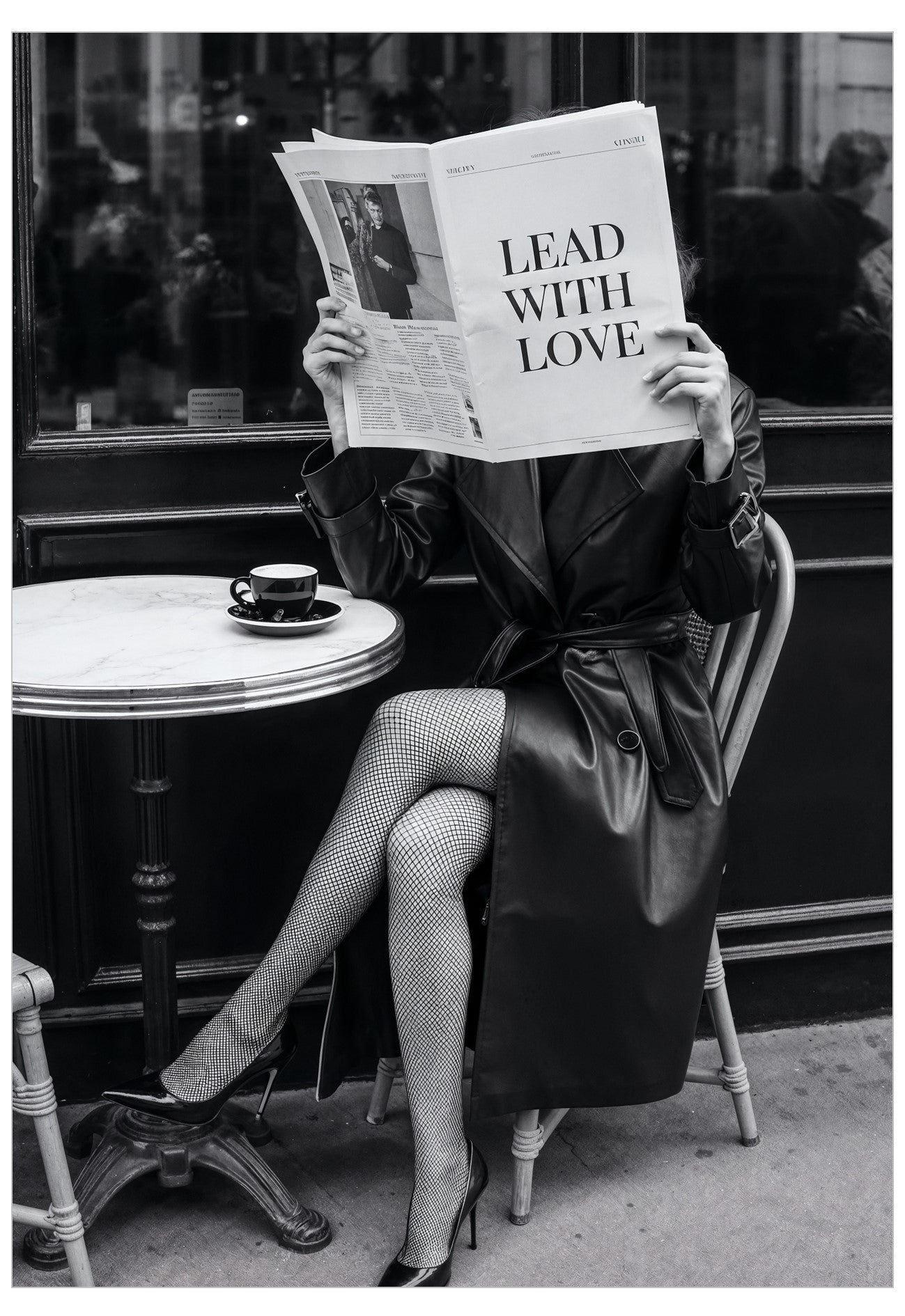Person sitting at a cafe table reading a newspaper with 'Lead with Love' headline.