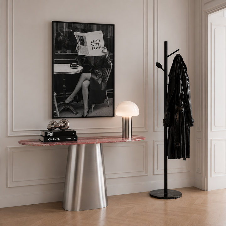 Black and white photography art in stylish hallway above stainless steel and pink marble console table