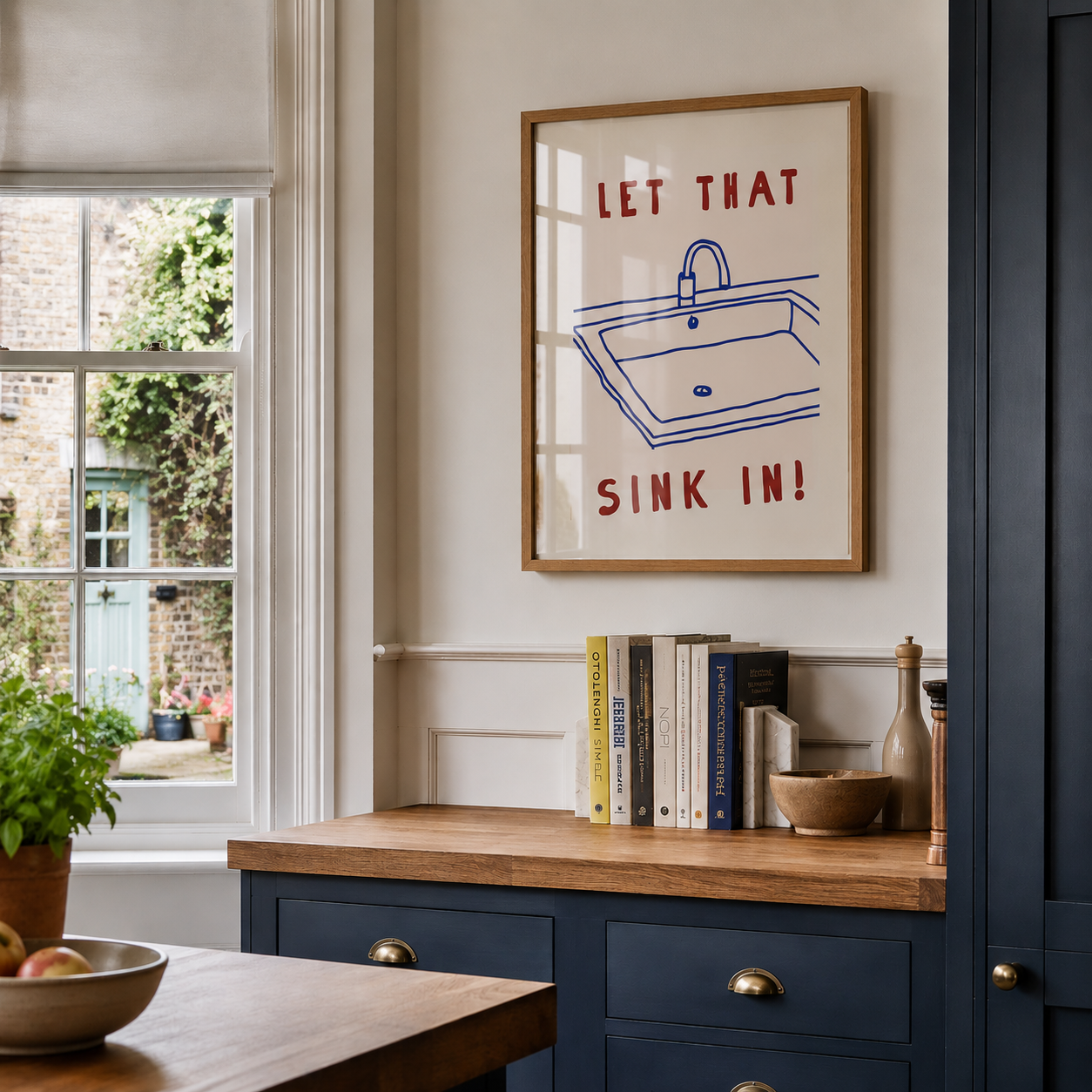 Kitchen interior with a framed poster on the wall and books on a counter.