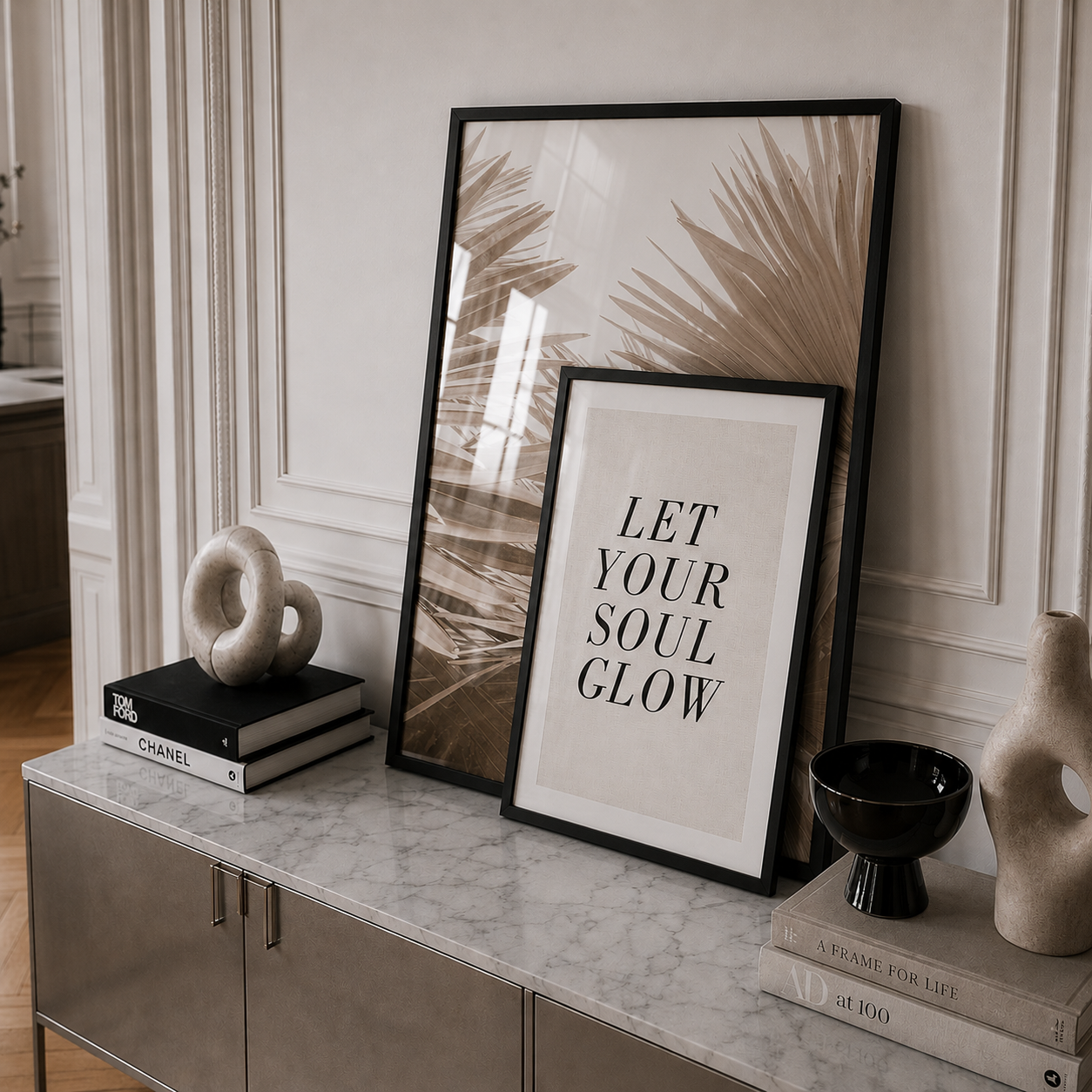 Decorative setup with framed art and sculptures on a marble surface.