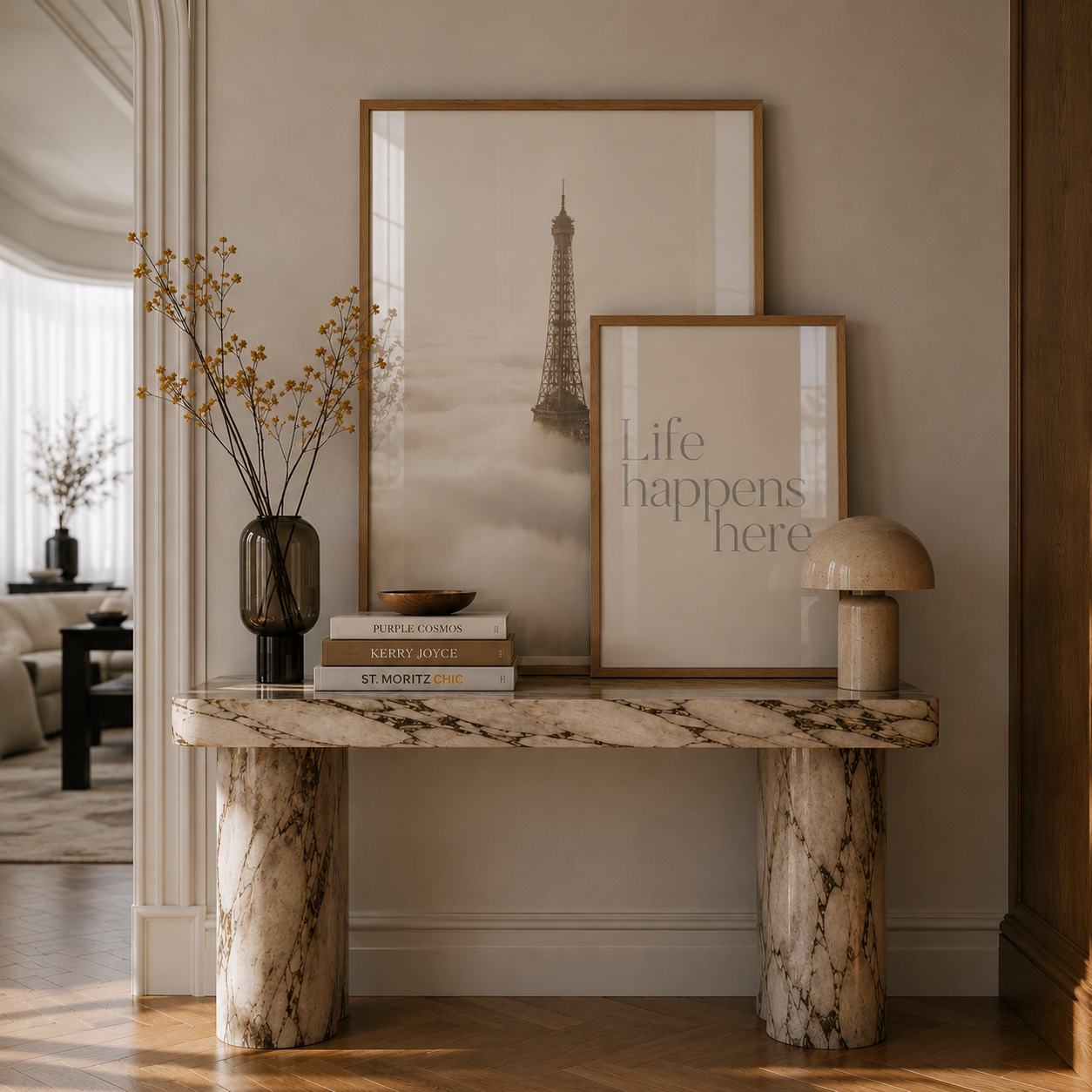 Marble console table with books and a vase in a room with framed art on the wall.