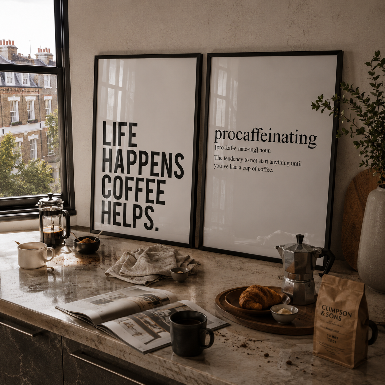 Kitchen counter with coffee-making items, framed prints, and a newspaper.