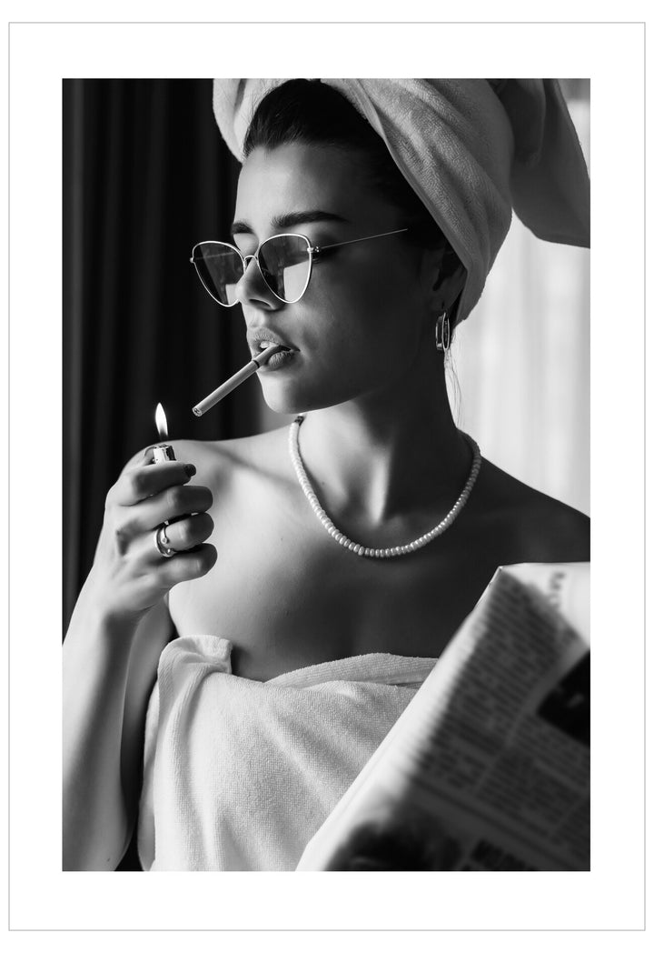 Black and white portrait of a woman with a towel wrapped around her head, holding a cigarette.
