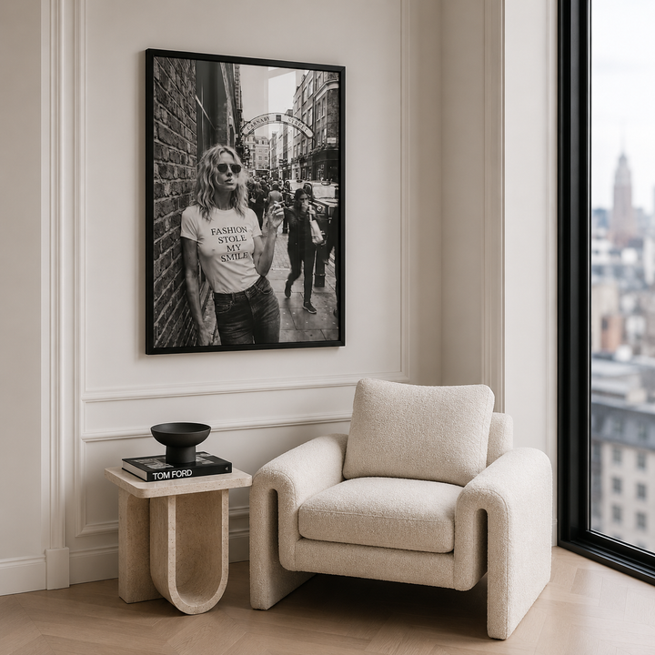 Modern living room with a beige armchair, side table, and framed black and white photo on the wall.