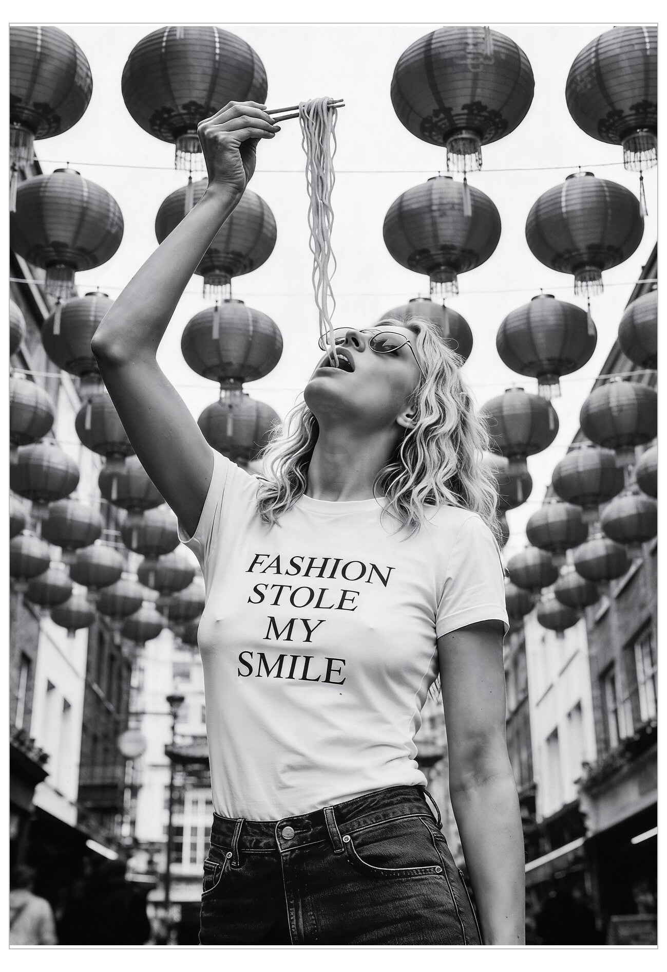 Woman wearing a t-shirt with 'Fashion Stole My Smile' text in an urban setting with hanging lanterns.