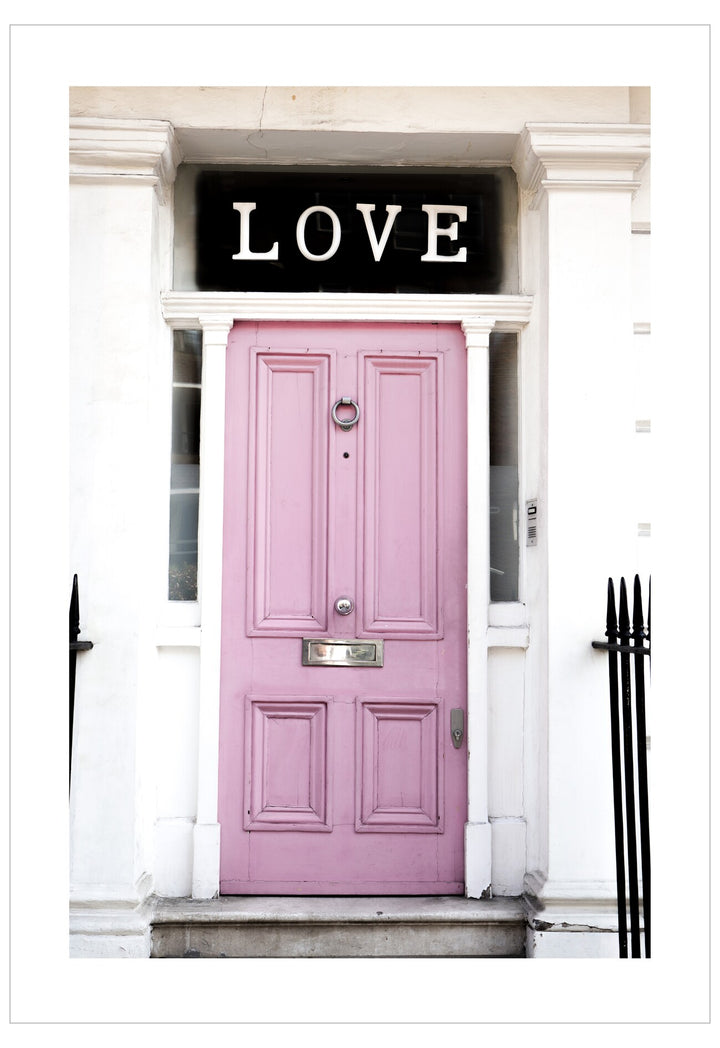 Pink door with 'LOVE' sign above it on a white building