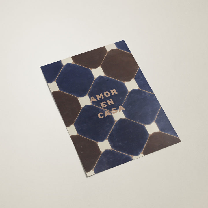 Decorative tile with hexagonal pattern and 'AMOR EN CASA' text on a light gray background