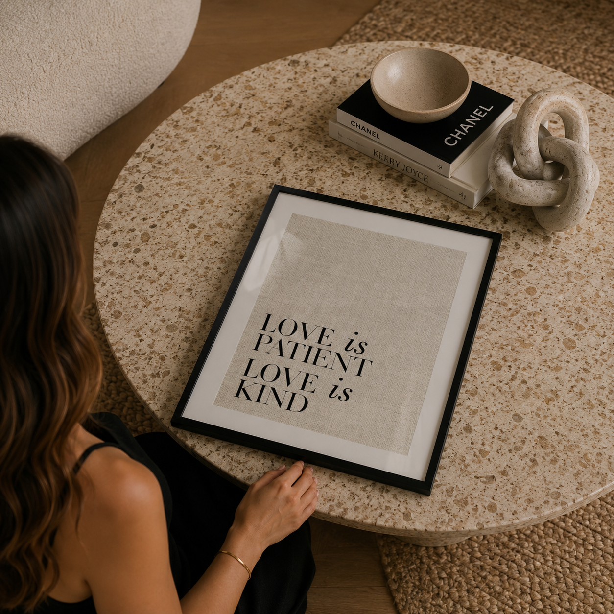 Person looking at a framed quote on a round table with decor items