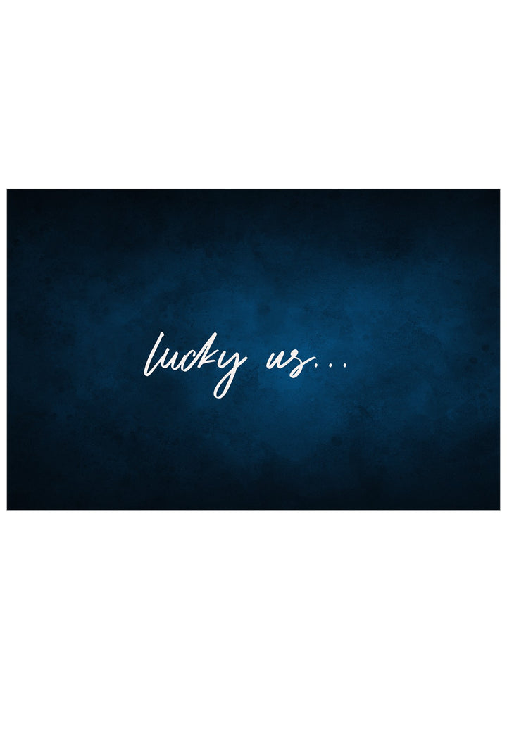A rectangular dark blue textured print with the phrase 'lucky us.