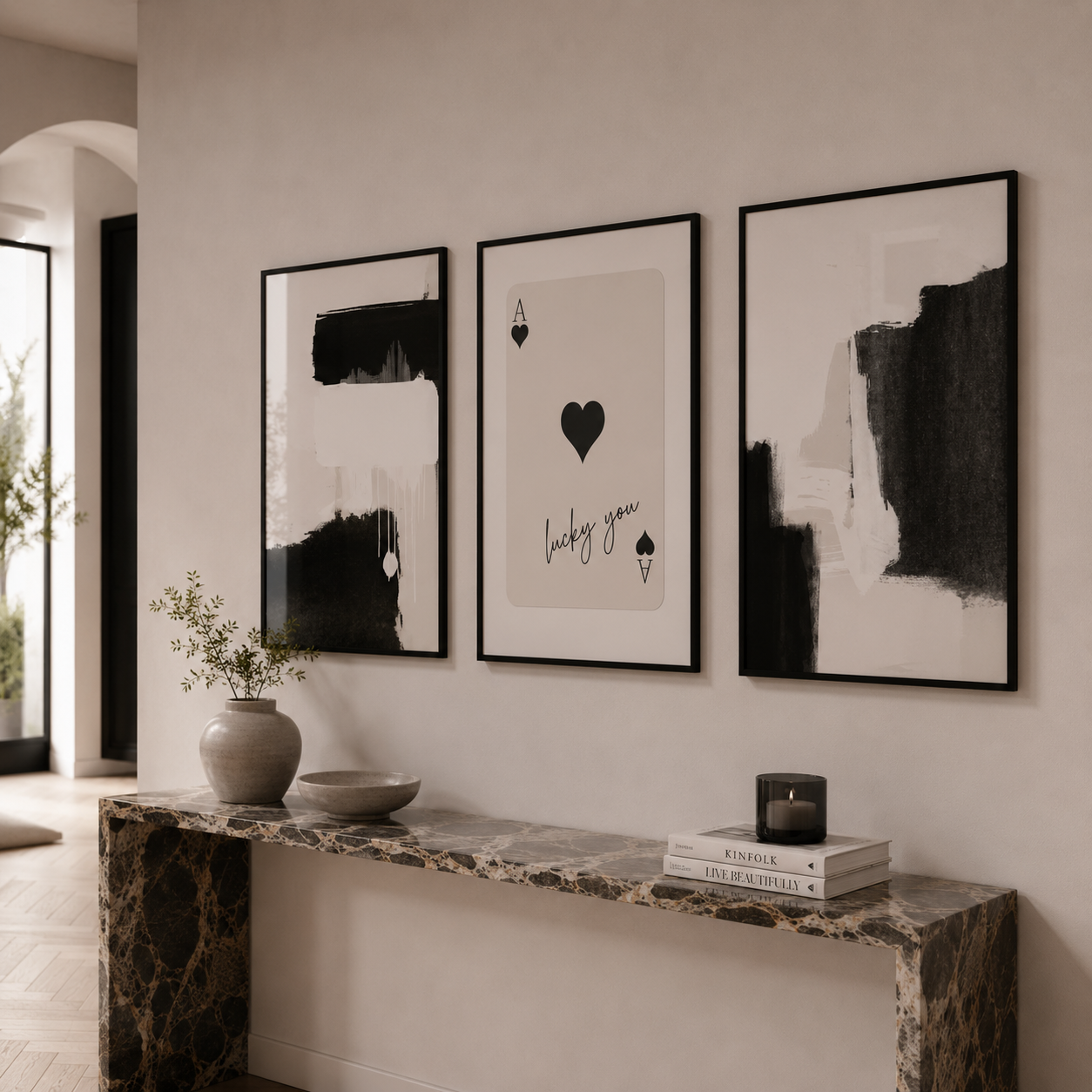Three framed abstract artworks on a wall above a marble console table.
