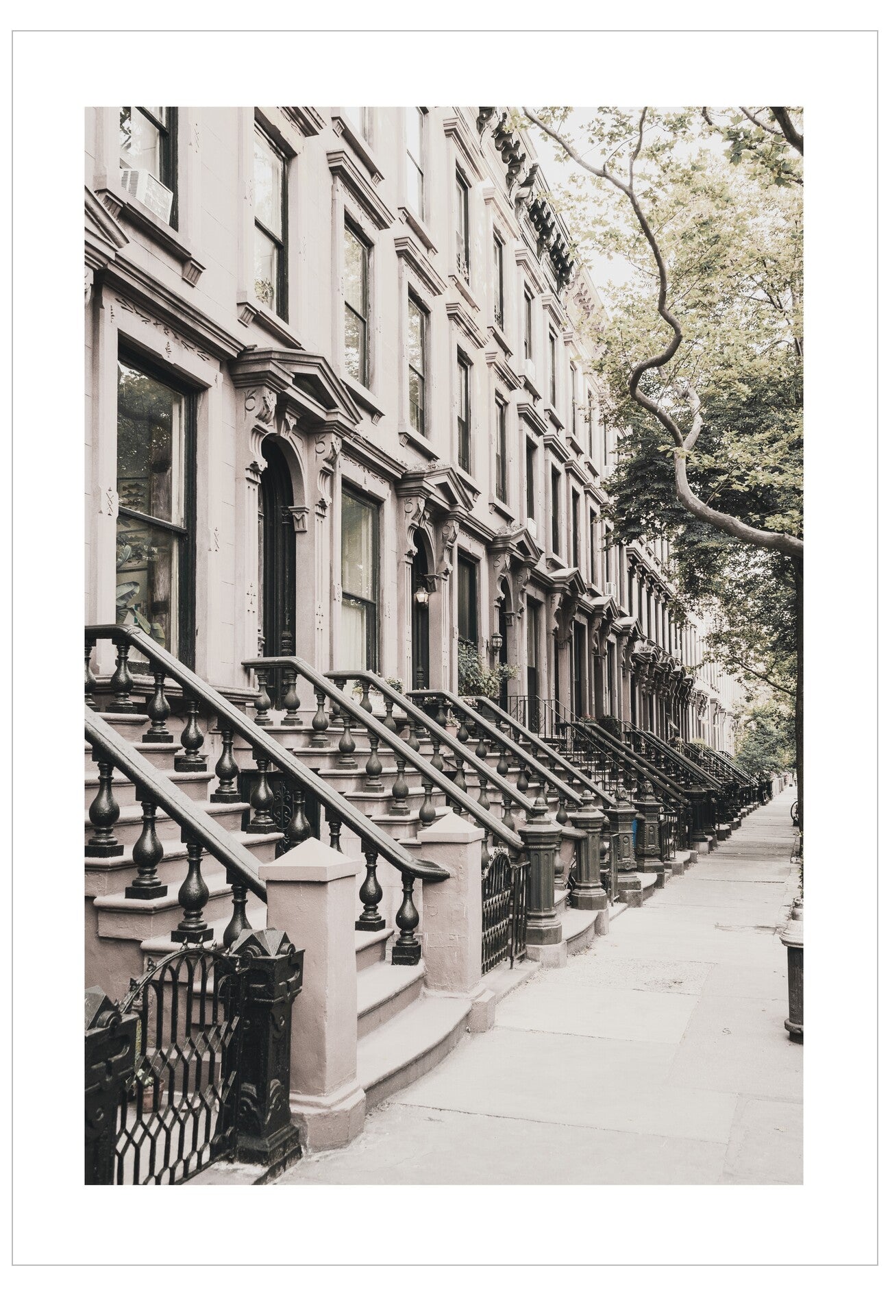 Row of brownstone houses with decorative front steps on a city street.
