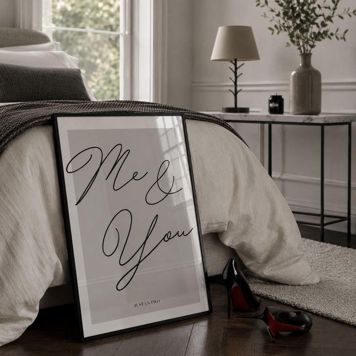 Framed artwork with 'Me & You' text on a bed in a bedroom setting