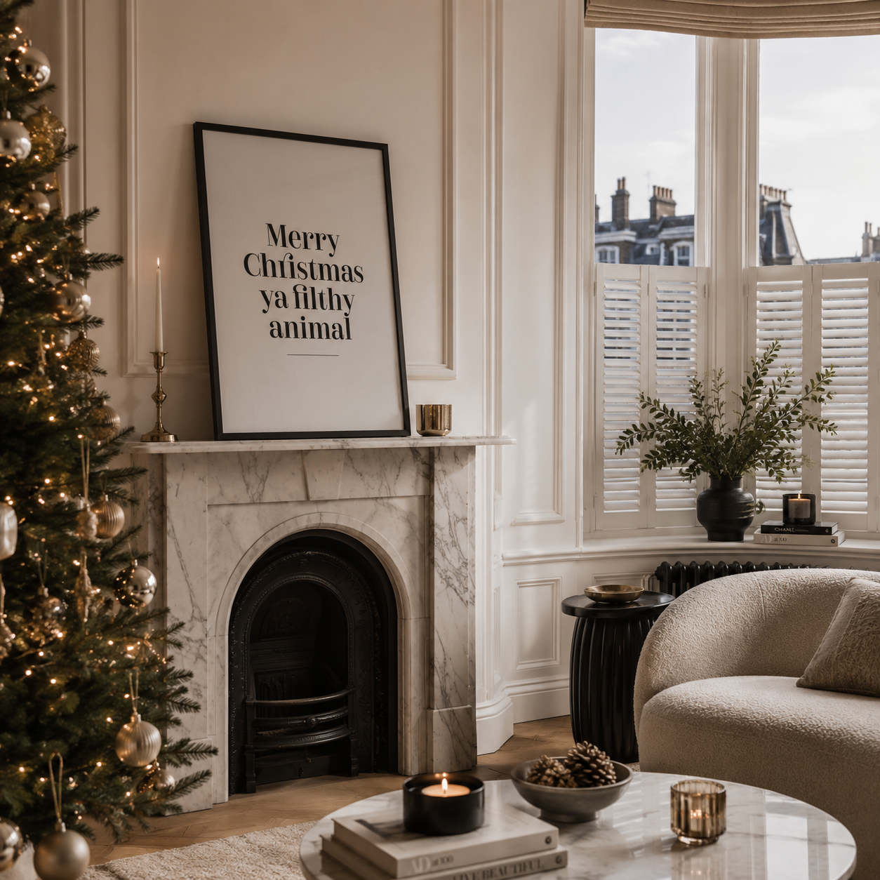 A framed black-and-white Christmas print reading 'Merry Christmas ya filthy animal' hangs on a marble fireplace mantel in a cozy living room with a lit Christmas tree, window shutters, and a beige armchair.