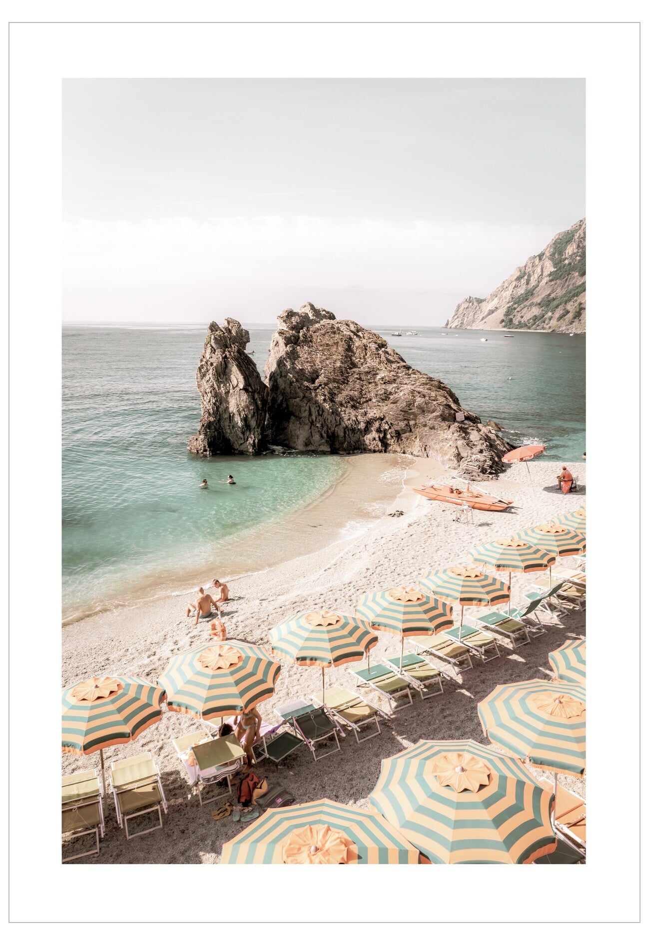 Beach scene with colorful umbrellas and chairs on a sandy shore with rocky outcrops and clear water.