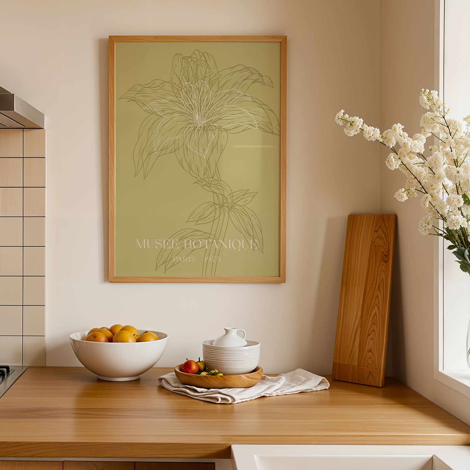Kitchen counter with a bowl of fruit, a teapot, and a plant poster on the wall.