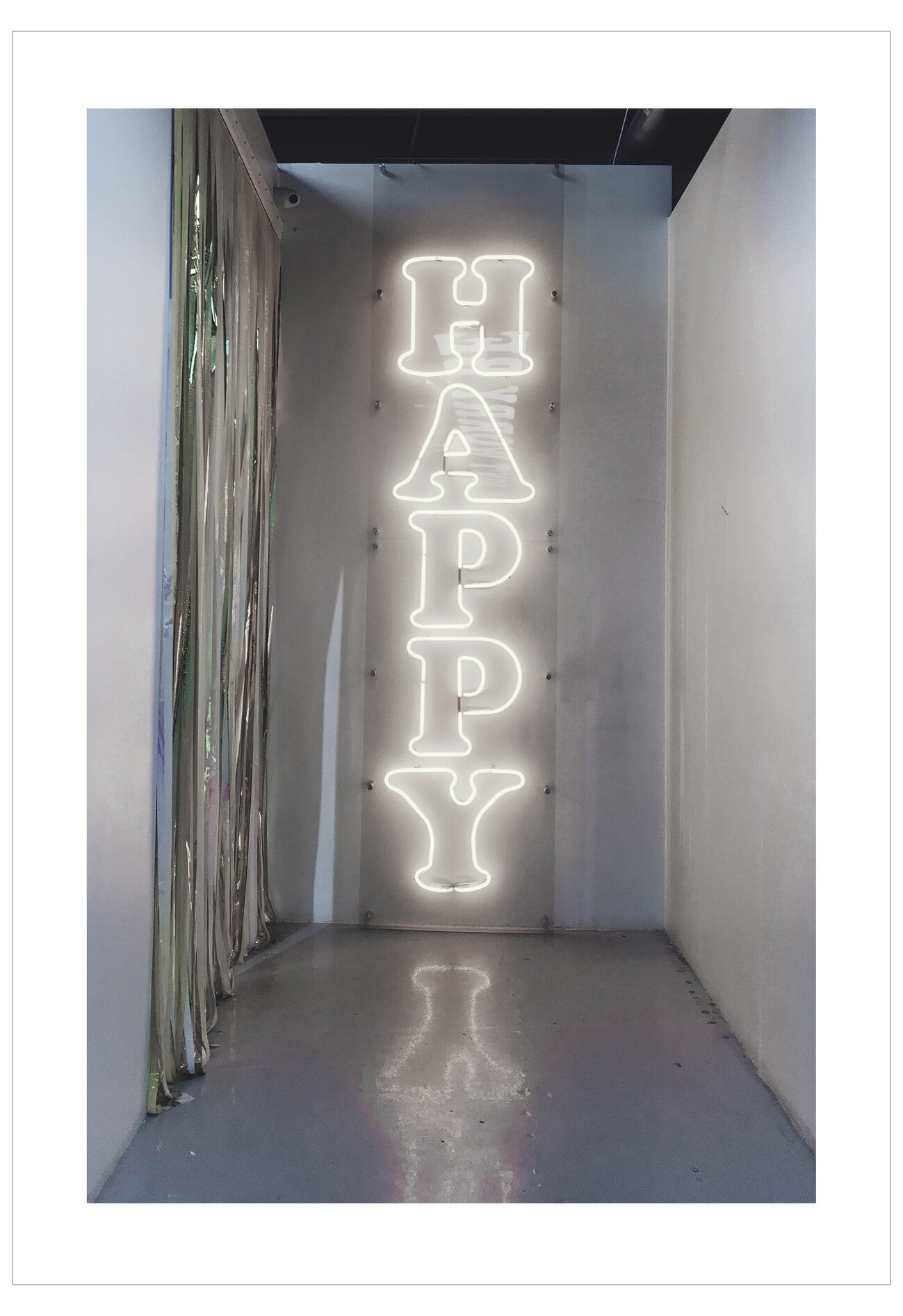 Neon sign spelling 'HAPPY' in a narrow hallway.